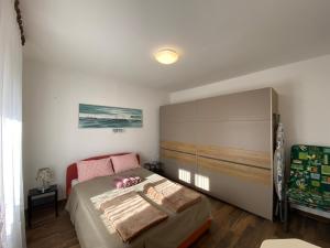 a bedroom with a bed and a large cabinet at Apartment Bigi in Novi Vinodolski