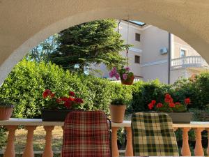 deux chaises assises sur une table avec des fleurs et des plantes dans l'établissement Apartment Bigi, à Novi Vinodolski