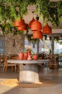 une table avec des vases orange dans un restaurant dans l'établissement Paralos Kyma Dunes Adults Only, à Mastichari