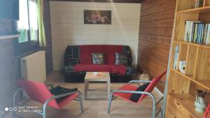 sala de estar con sillas rojas y sofá en Le petit chalet en Gapennes