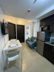 a kitchen and living room with a table and a couch at 2-bedroom Condo Unit in Manila