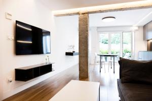 a living room with a couch and a tv on a wall at Kofradia in Hondarribia