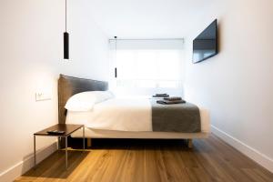 1 dormitorio con cama, mesa y ventana en Kofradia en Hondarribia