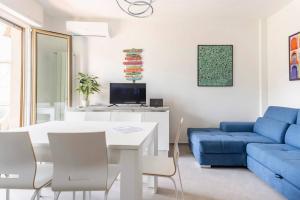 uma sala de estar com uma mesa e um sofá azul em Spazioso appartamento a 5 minuti a piedi dal mare em Massa