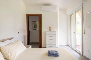 um quarto branco com uma cama e uma cómoda em Spazioso appartamento a 5 minuti a piedi dal mare em Massa