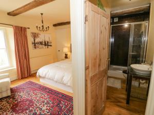 ein Schlafzimmer mit einem Bett und ein Badezimmer mit einem Waschbecken in der Unterkunft Glapthorn Manor in Peterborough