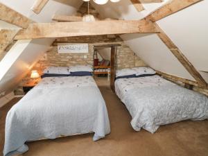 two beds in a attic bedroom with exposed beams at Glapthorn Manor in Peterborough