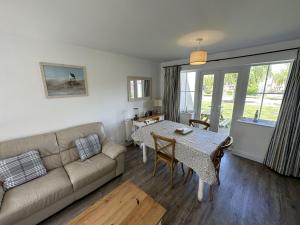 a living room with a couch and a table at Lees Plaice - Part of the The Bay Filey Holiday Village with pool, gym and direct beach access, pub, restaurant, tennis and meadows walks in Filey