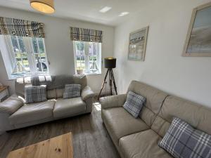 a living room with a couch and a table at Lees Plaice - Part of the The Bay Filey Holiday Village with pool, gym and direct beach access, pub, restaurant, tennis and meadows walks in Filey