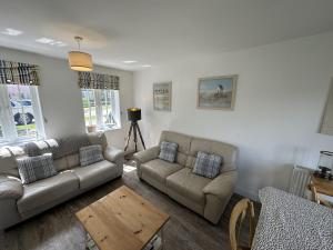 a living room with two couches and a table at Lees Plaice - Part of the The Bay Filey Holiday Village with pool, gym and direct beach access, pub, restaurant, tennis and meadows walks in Filey