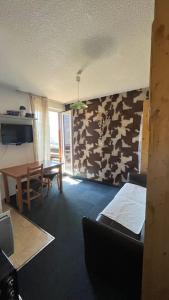 a living room with a table and a dining room at Le Cow'sy 1800 in Les Deux Alpes