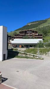 a building on a hill next to a parking lot at Le Cow'sy 1800 in Les Deux Alpes