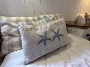 a pillow sitting on top of a bed at Azure Beach House - Part of the The Bay Filey Holiday Village with pool, gym and direct beach access, pub, restaurant, tennis and meadows walks in Filey +40 photos