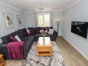 ein Wohnzimmer mit Sofa und Tisch in der Unterkunft Mews Cottage in Carmarthen