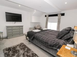 ein Schlafzimmer mit einem Bett und einem TV an der Wand in der Unterkunft Capel Mawr, Basement 19 in Caernarfon