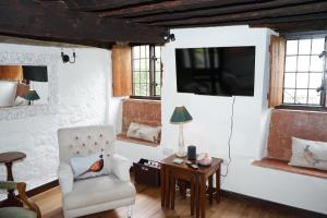 a living room with a chair and a tv at Character 2 double bedroom cottage in Shaftesbury in Shaftesbury