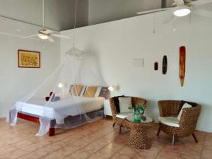 1 dormitorio con 1 cama, mesa y sillas en Villa San Sebastian Curaçao en Fontein