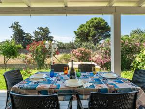 - une table avec des assiettes et des verres à vin sur la terrasse dans l'établissement Villa Lunu, à Quartu SantʼElena