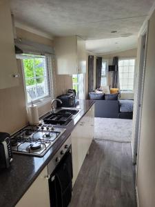 a kitchen with a stove and a living room at Cherry Blossom Retreat in Felton