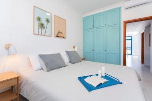 Schlafzimmer mit einem großen weißen Bett und blauen Schränken in der Unterkunft Agaete White&Blue House in Agaete