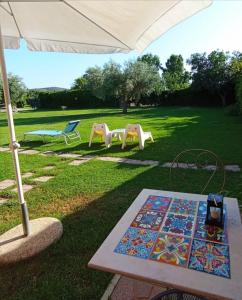 een tafel en twee stoelen en een paraplu bij "IL CASALE DEI GIRASOLI" Country House in Capalbio in Capalbio