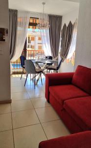 - un salon avec un canapé rouge et une table dans l'établissement Sunny apartament near La Mata beach, à Torrevieja