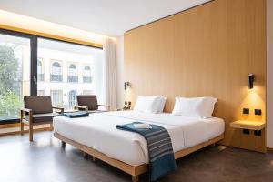 ein Schlafzimmer mit einem großen Bett und einem großen Fenster in der Unterkunft Evora Olive Hotel in Évora