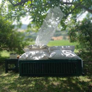 a bed sitting in the grass in a field at Le Bumbarelle in Tavoleto