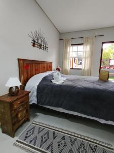 1 dormitorio con cama, mesa y ventana en Pouso Casa da Vovó, en Tiradentes