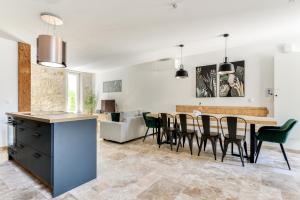 - une cuisine et une salle à manger avec une table et des chaises dans l'établissement Grande villa de charme proche de la mer, à Peyriac-de-Mer