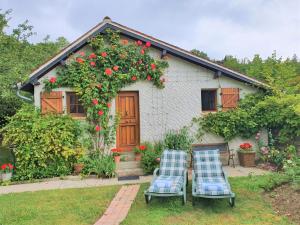 dos sillas frente a una casa con rosas en Aux Marguerites, en Sainte-Geneviève-lès-Gasny