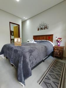 a bedroom with a large bed with a large blanket at Pouso Casa da Vovó in Tiradentes