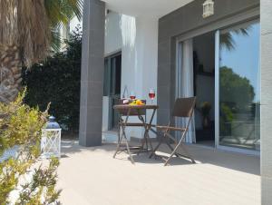 a table with two chairs and a glass of wine at Bungalow en Punta Prima 2 dormitorios y piscina in Torrevieja