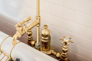 ein Badezimmer mit goldenen Armaturen und einem Waschbecken in der Unterkunft One of These Nights - King Sized Bed - Sleeps 2 in Lynchburg
