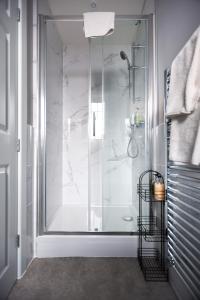 y baño con ducha y puerta de cristal. en Cransley Apart Hotel, en Bournemouth