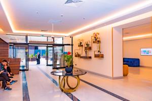 a lobby of a building with a table and people at Orbi City Inn in Batumi