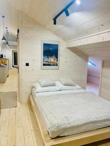 a bedroom with a large bed in a wooden room at Apartament Widoknastok in Korbielów