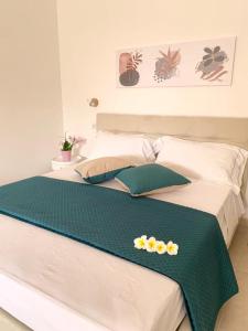 - un lit avec une couverture verte et blanche dans l'établissement B&B Jolie Suite, à Villasimius