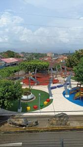 einen Park mit einem Spielplatz mit Rutschen und Bäumen in der Unterkunft Apartamento Banda de Shilcayo in Tarapoto