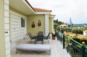 a patio with a table and chairs on a balcony at Villa Theano - Family House in Lixouri, Kefalonia in Lixouri