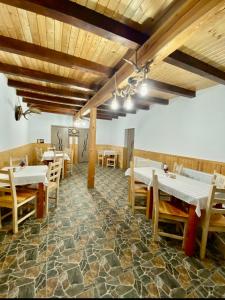 a restaurant with tables and chairs in a room at Casa Mis in Baia de Fier