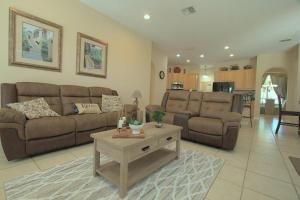 uma sala de estar com um sofá e uma mesa de centro em Entire home with pool and lake view and Golf course by Disney em Davenport
