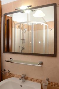 bagno con specchio e lavandino di Appartamenti Fronte mare a Siniscola