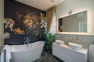 a bathroom with a tub and a large mirror at Albert Cottage Hotel in East Cowes