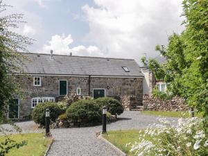 an old stone house with a garden in front of it at No 2 The Stables in Llangefni