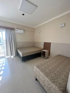 a hotel room with two beds and a window at SPAZZIO DIROMA - ACQUA PARK in Caldas Novas