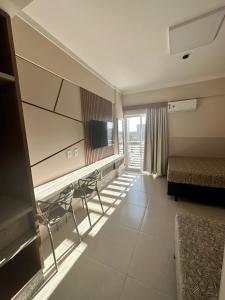 カルダス・ノバスにあるSPAZZIO DIROMA - ACQUA PARKのベッド、テーブル、椅子が備わる客室です。
