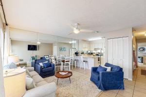 a living room with blue couches and a dining room at Southwind C-2 in Panama City Beach