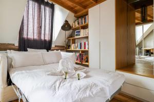 1 dormitorio con cama blanca y estante para libros en Charming flat right by the Jardin du Luxembourg - Welkeys en París
