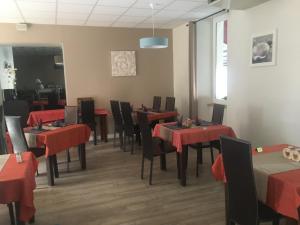 - une salle à manger avec des tables et des chaises rouge dans l'établissement HOTEL LES MARRONNIERS, à Thueyts